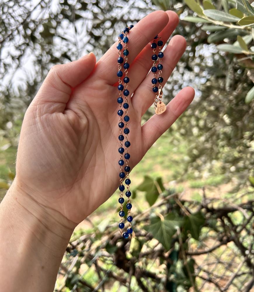 Girocollo in agate blu e argento 925 rosè.
La collana è realizzata in modo artigianale annodando a mano filo di argento e pietre nel nostro laboratorio di Carrè in provincia di Vicenza, garantendo cosi l