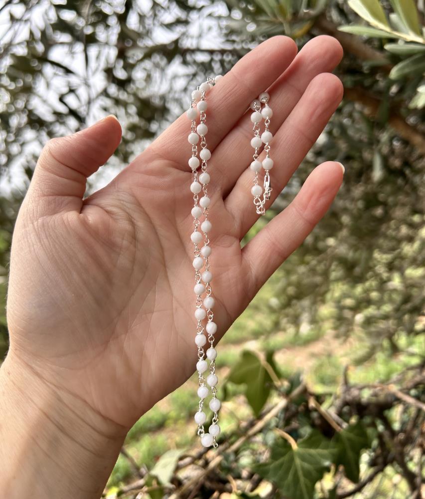 Girocollo in agate bianche e argento 925 color naturale.
La collana è realizzata in modo artigianale annodando a mano filo di argento e pietre nel nostro laboratorio di Carrè in provincia di Vicenza, garantendo cosi l