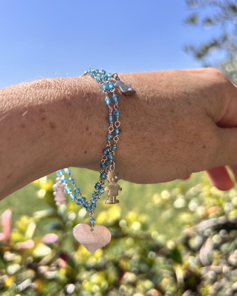 Braccialetto realizzato in argento 925 rodiato con zirconi azzurri.
Il braccialetto è un gioiello artigianale made in italy realizzato da noi nel nostro laboratorio di Vicenza. Il braccialetto è composto da due fili di catena a rosario dove sono inseriti cinque charms a forma di cuore, casetta, bambino, bambina, cagnolino, di grandezze diverse. Il braccialetto viene spedito con il suo cofanetto e borsetta regalo.