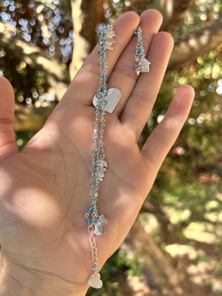 Braccialetto realizzato in argento 925 rodiato con zirconi azzurri.
Il braccialetto è un gioiello artigianale made in italy realizzato da noi nel nostro laboratorio di Vicenza. Il braccialetto è composto da due fili di catena a rosario dove sono inseriti cinque charms a forma di cuore, casetta, bambino, bambina, cagnolino, di grandezze diverse. Il braccialetto viene spedito con il suo cofanetto e borsetta regalo.
