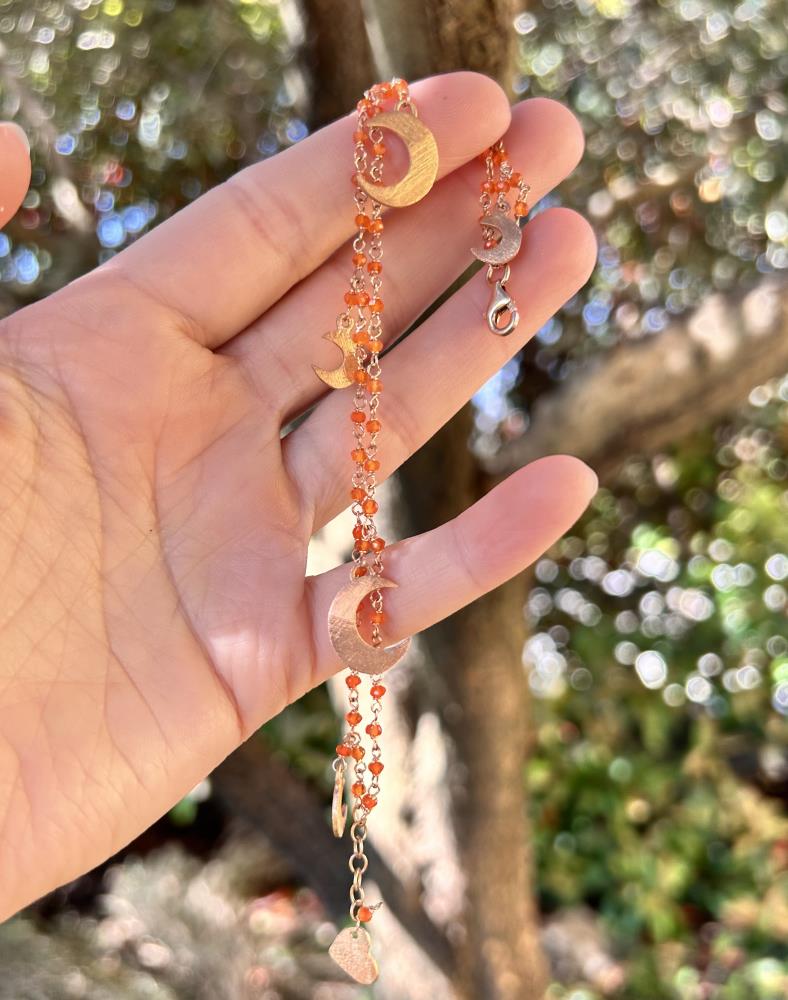 Braccialetto realizzato in argento 925 rosè con corniola arancione.
Il braccialetto è un gioiello artigianale made in italy realizzato da noi nel nostro laboratorio di Vicenza. Il braccialetto è composto da due fili di catena a rosario dove sono inseriti cinque charms a forma di lune, tre piccole e due grandi. Il braccialetto viene spedito con il suo cofanetto e borsetta regalo.