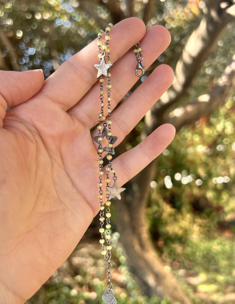 Braccialetto realizzato in argento 925 brunito con zirconi color verde chiaro.
Il braccialetto è un gioiello artigianale made in italy realizzato da noi nel nostro laboratorio di Vicenza. Il braccialetto è composto da due fili di catena a rosario dove sono inseriti tre charms a forma di stella. Il braccialetto viene spedito con il suo cofanetto e borsetta regalo.